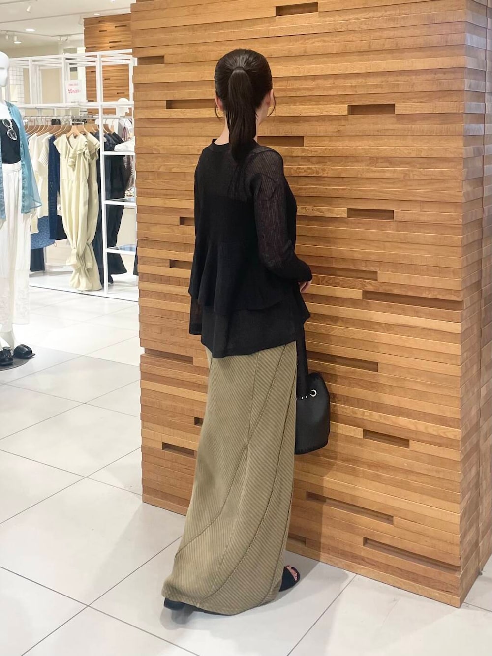 ブラック系のカーディガン/ボレロ、ブラック系のサンダル、イエロー系のスカートを着用したレディースの夏コーディネートの2枚目の写真