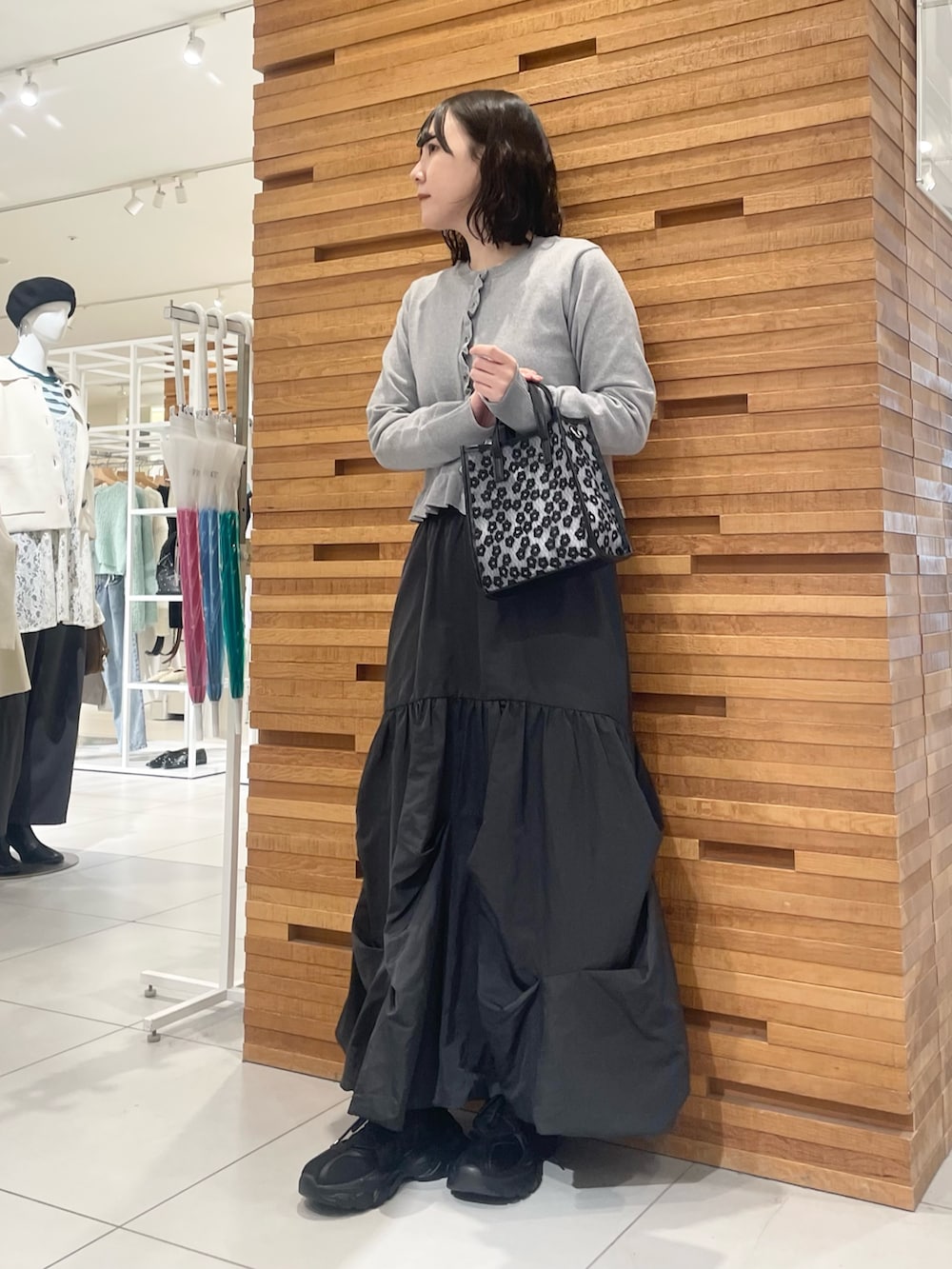 ブラック系のスニーカー、グレー系のニット/セーター、グレー系のスカートを着用したレディースの冬コーディネートの2枚目の写真