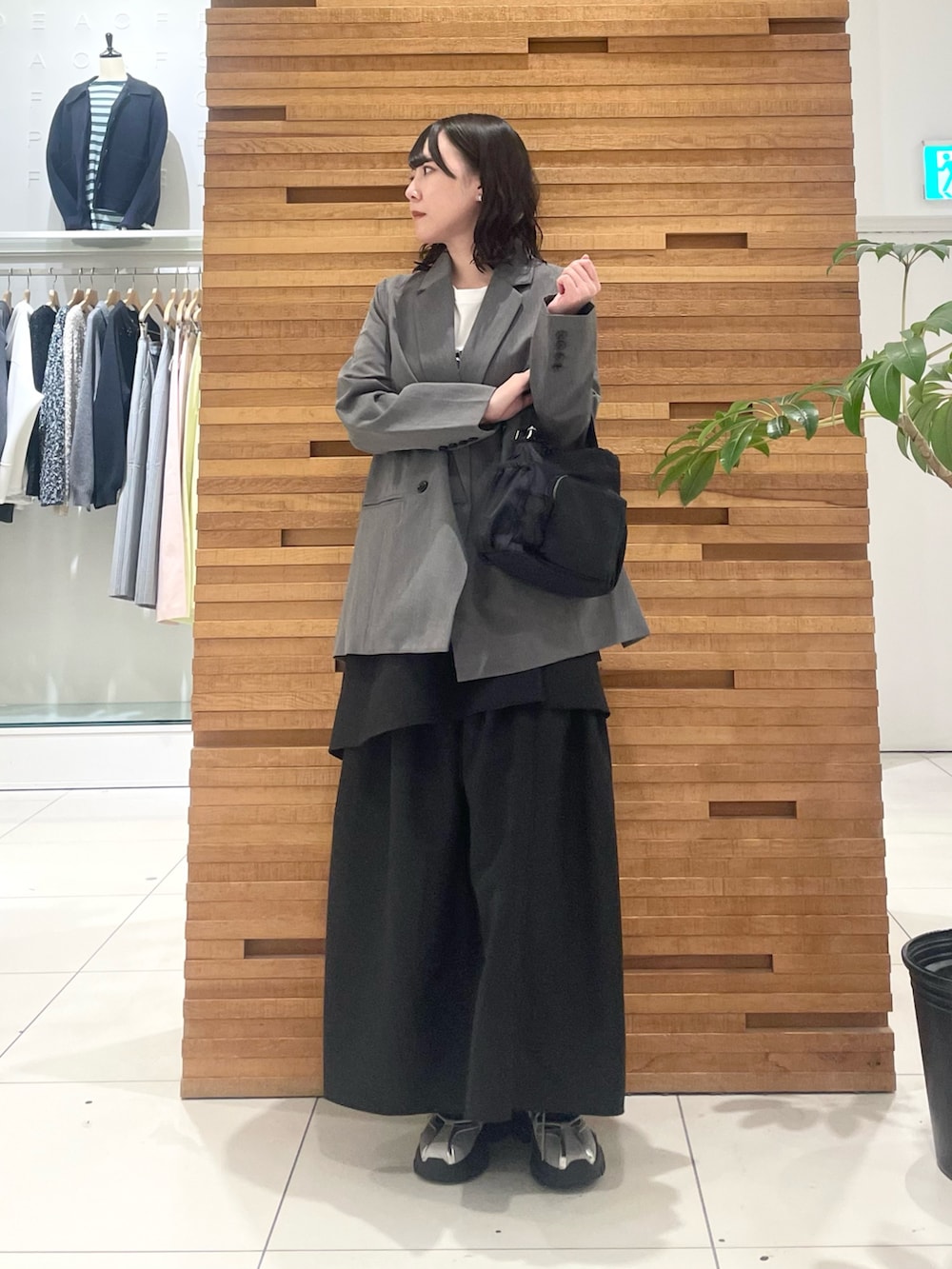 グレー系のスニーカー、ブラック系のスカート、グレー系のテーラードジャケットを着用したレディースの春コーディネートの2枚目の写真