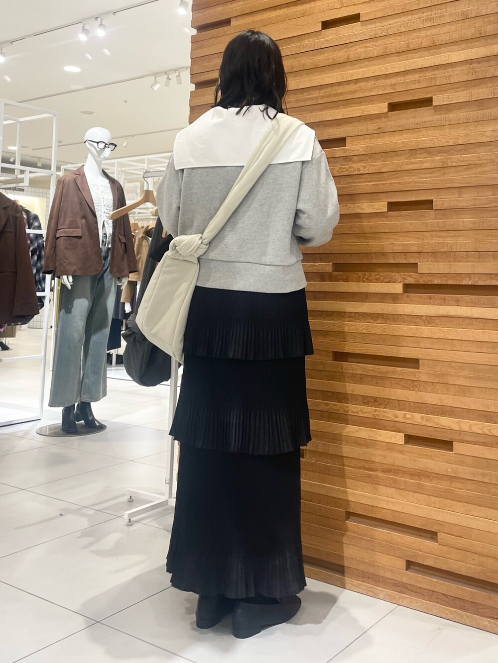 ホワイト系のショルダーバッグ、グレー系のスウェット、ブラック系のスカートを着用したレディースの秋コーディネートの3枚目の写真