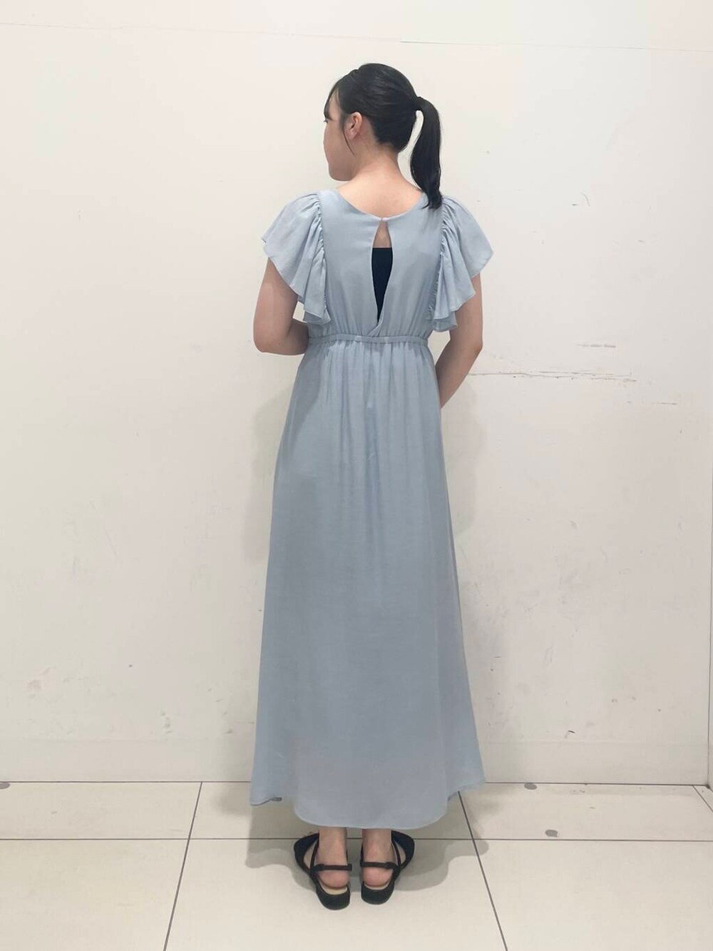 ブラック系のハンドバッグ、ブルー系のワンピース、ブラック系のサンダルを着用したレディースの夏コーディネートの3枚目の写真