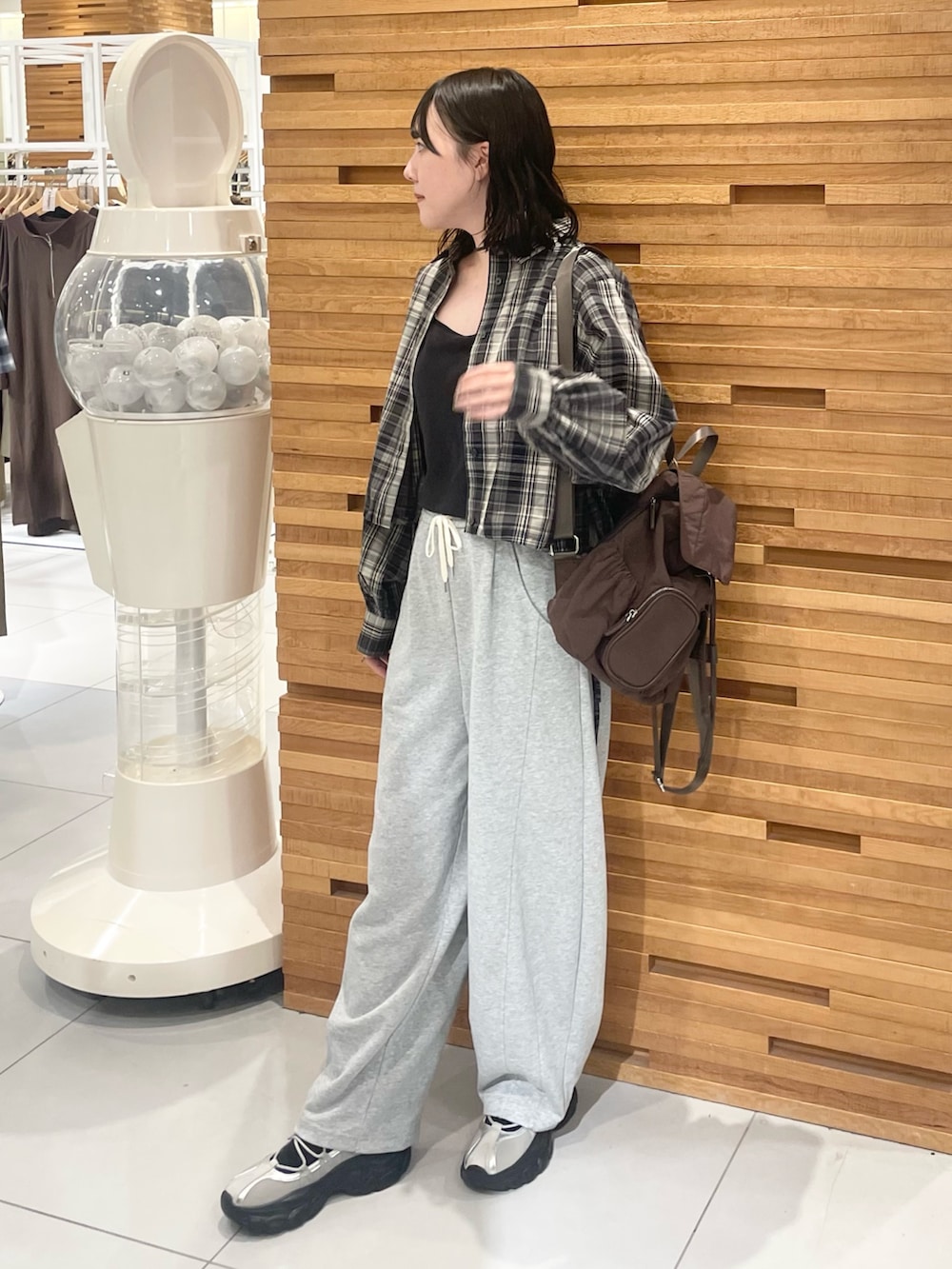 ブラウン系のバックパック/リュック、グレー系のその他パンツ、ブラック系のシャツ/ブラウスを着用したレディースの秋コーディネートの2枚目の写真