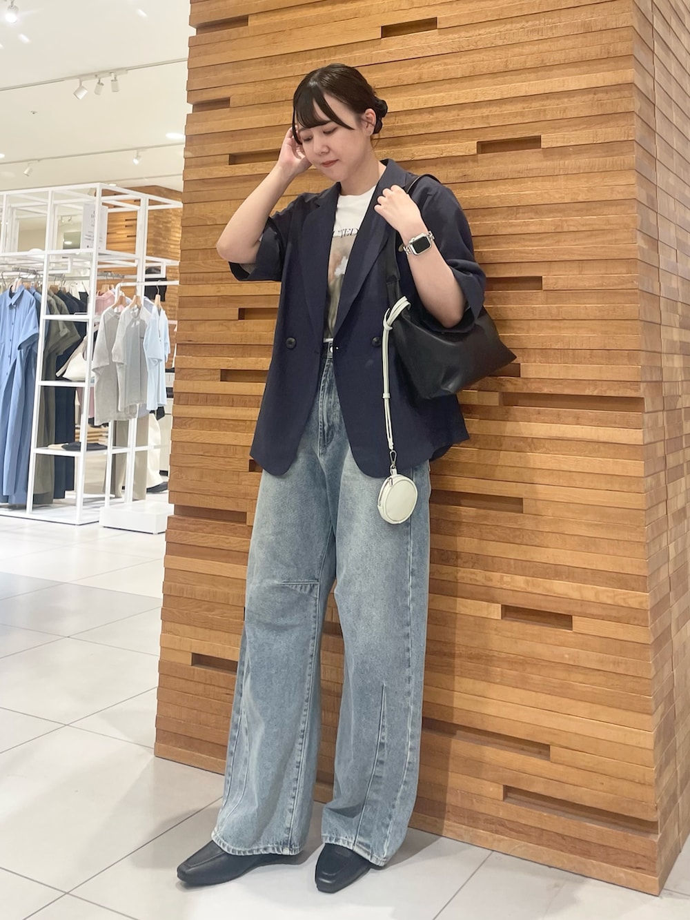 ブルー系のその他アウター、ブラック系のハンドバッグ、その他のTシャツ/カットソーを着用したレディースの春コーディネートの2枚目の写真