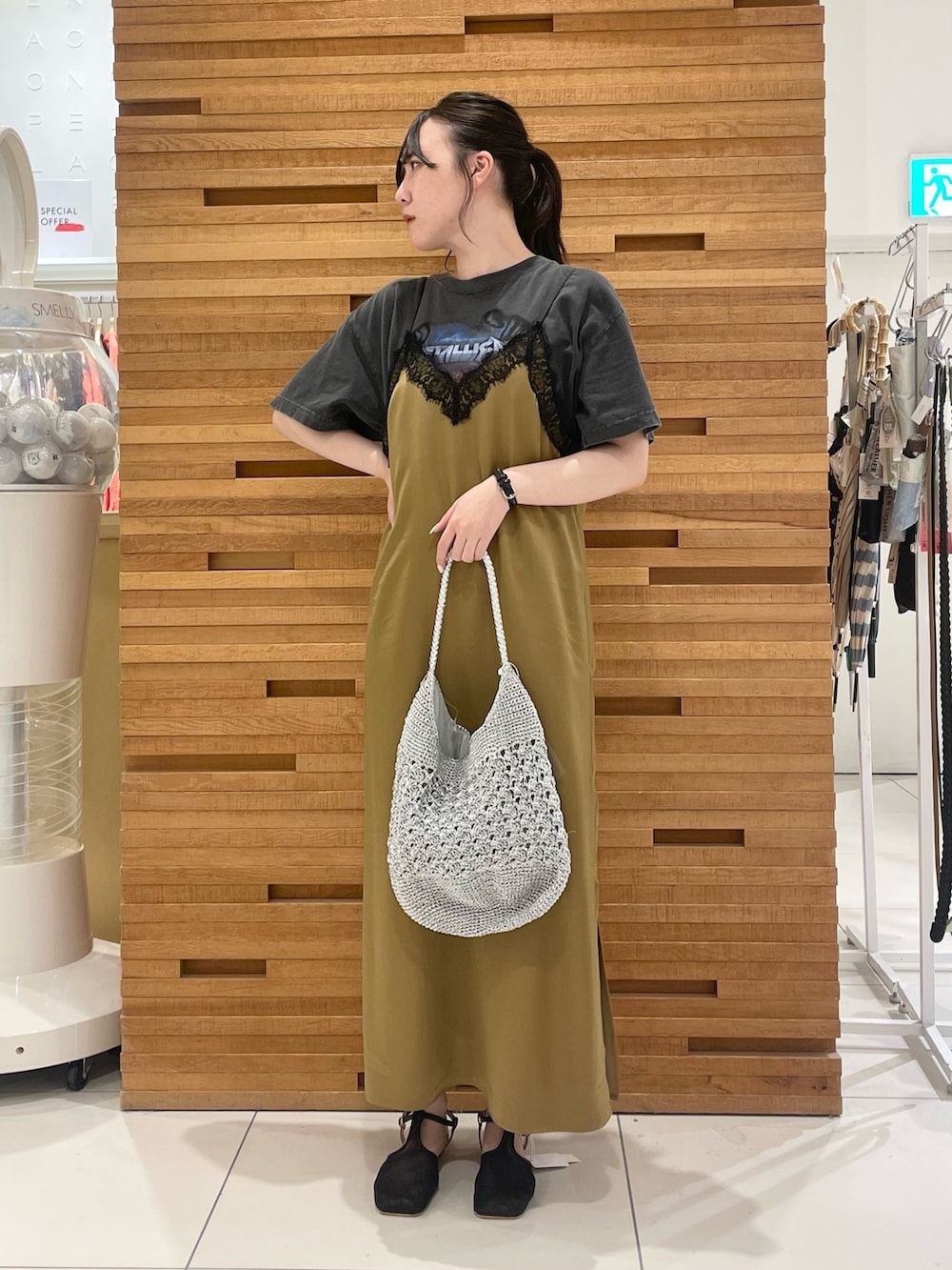 ベージュ系のワンピース、ブラック系のTシャツ/カットソー、シルバー系のショルダーバッグを着用したレディースの夏コーディネートの2枚目の写真