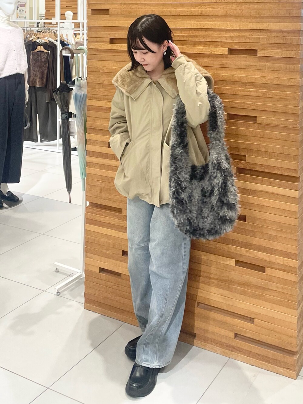 グレー系のトートバッグ、ブルー系のデニムパンツ、ブラック系のローファーを着用したレディースの秋コーディネートの3枚目の写真