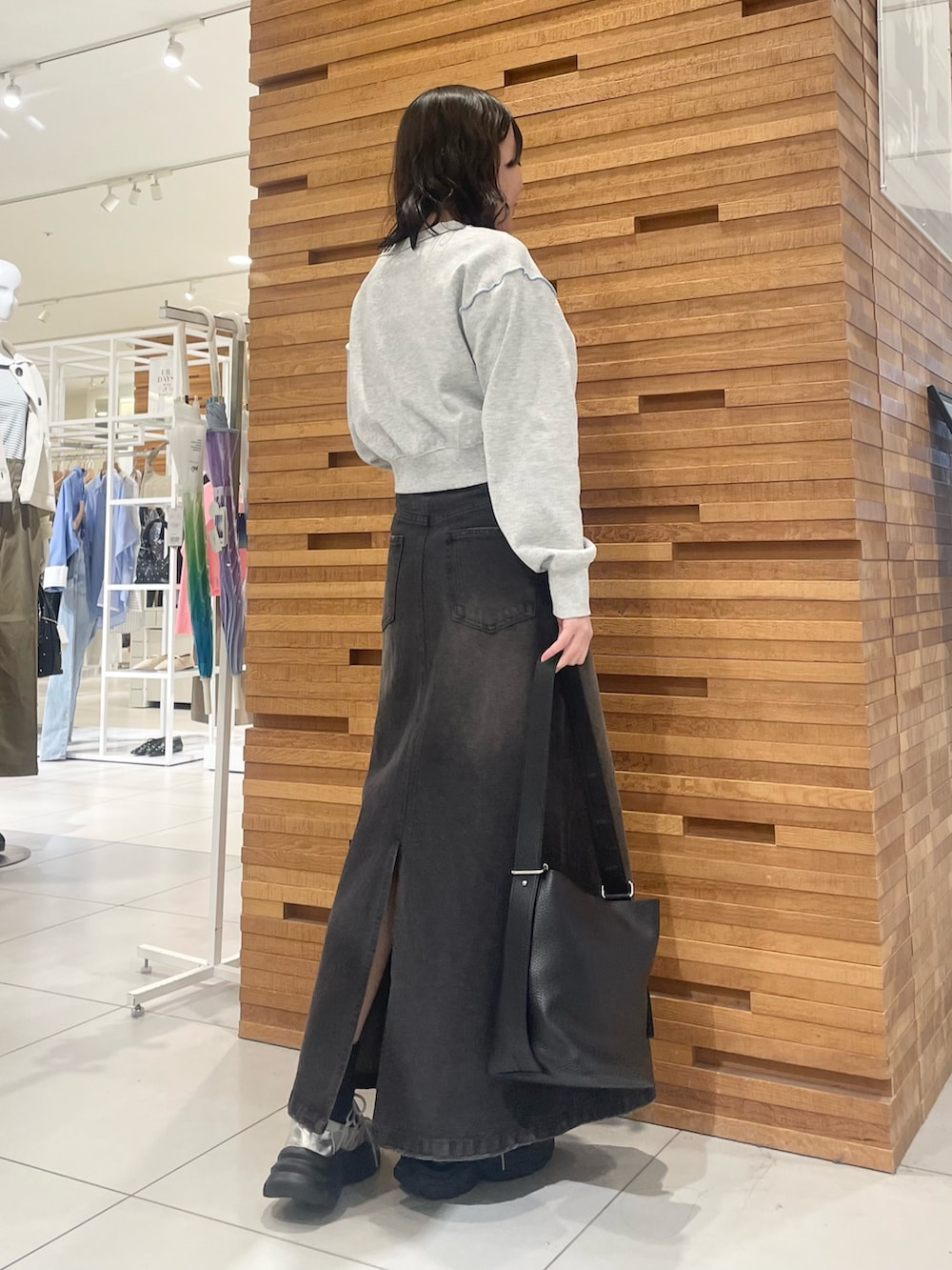 ブラック系のスカート、グレー系のスニーカー、グレー系のスウェットを着用したレディースの春コーディネートの3枚目の写真