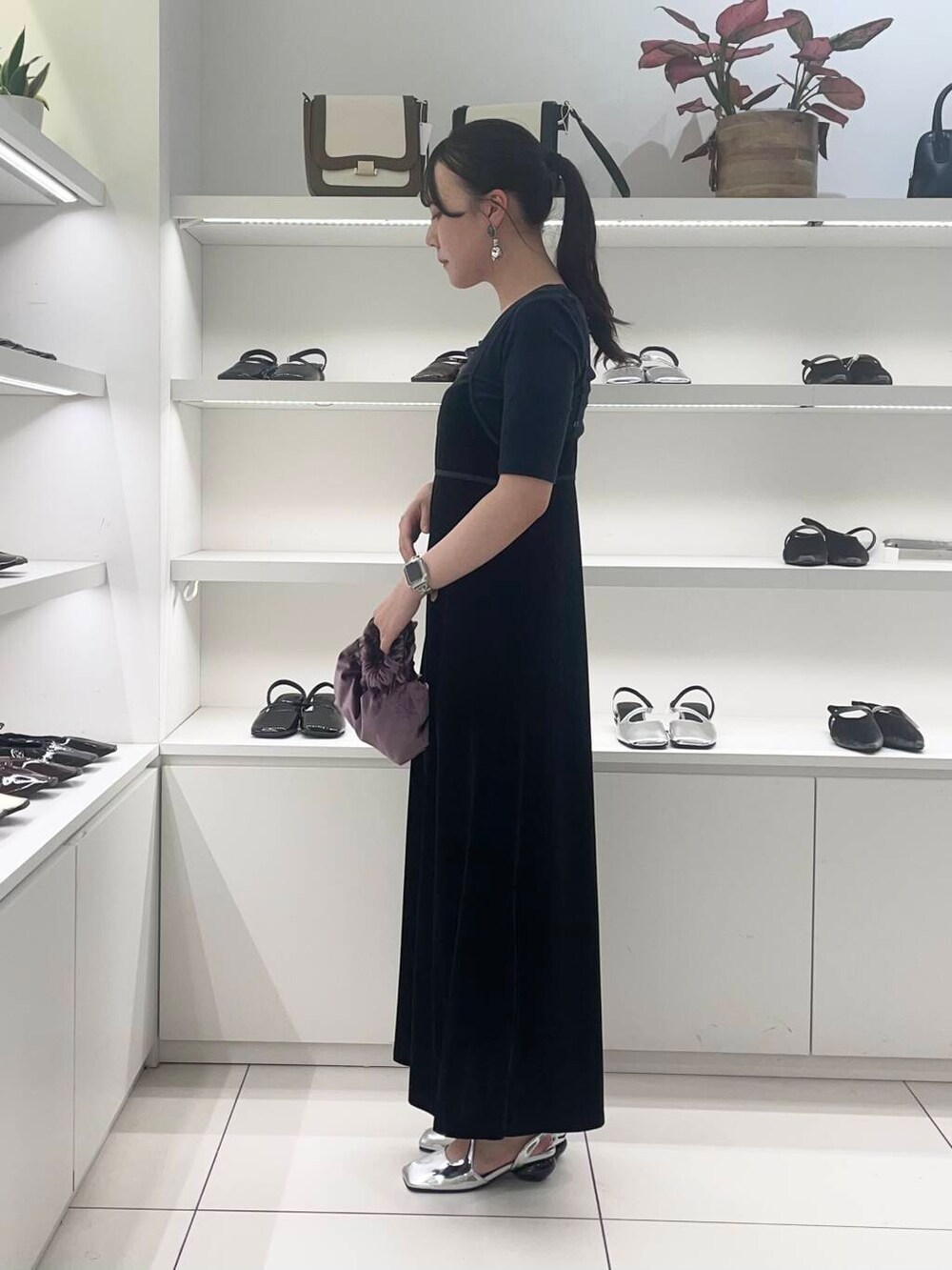 パープル系のハンドバッグ、シルバー系のその他シューズ、ブラック系のワンピースを着用したレディースの夏コーディネートの2枚目の写真