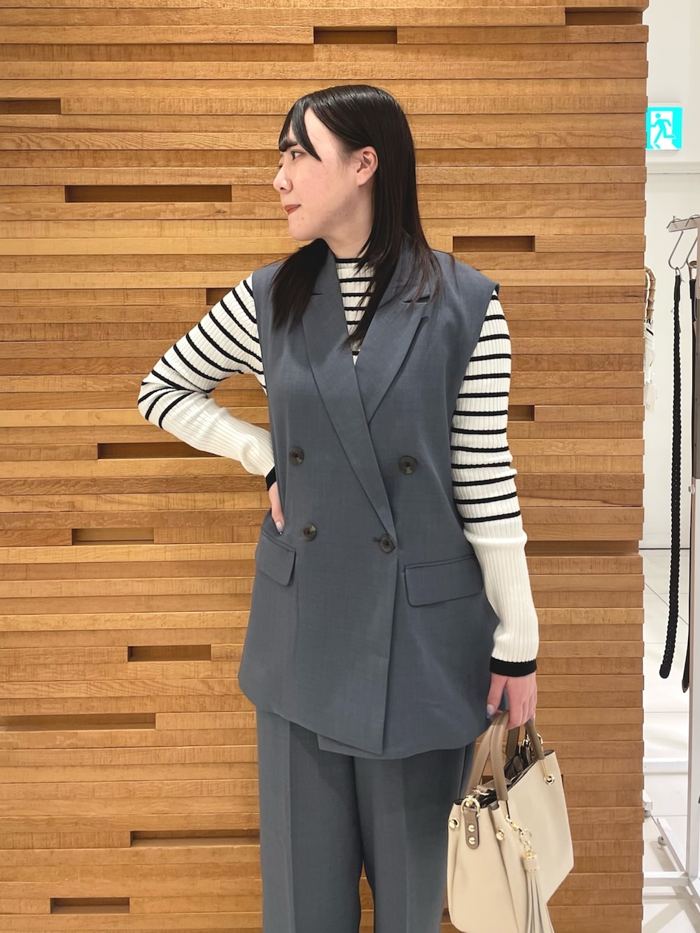 ブルー系のその他パンツ、ホワイト系のニット/セーター、ブラック系のブーツを着用したレディースの春コーディネートの3枚目の写真