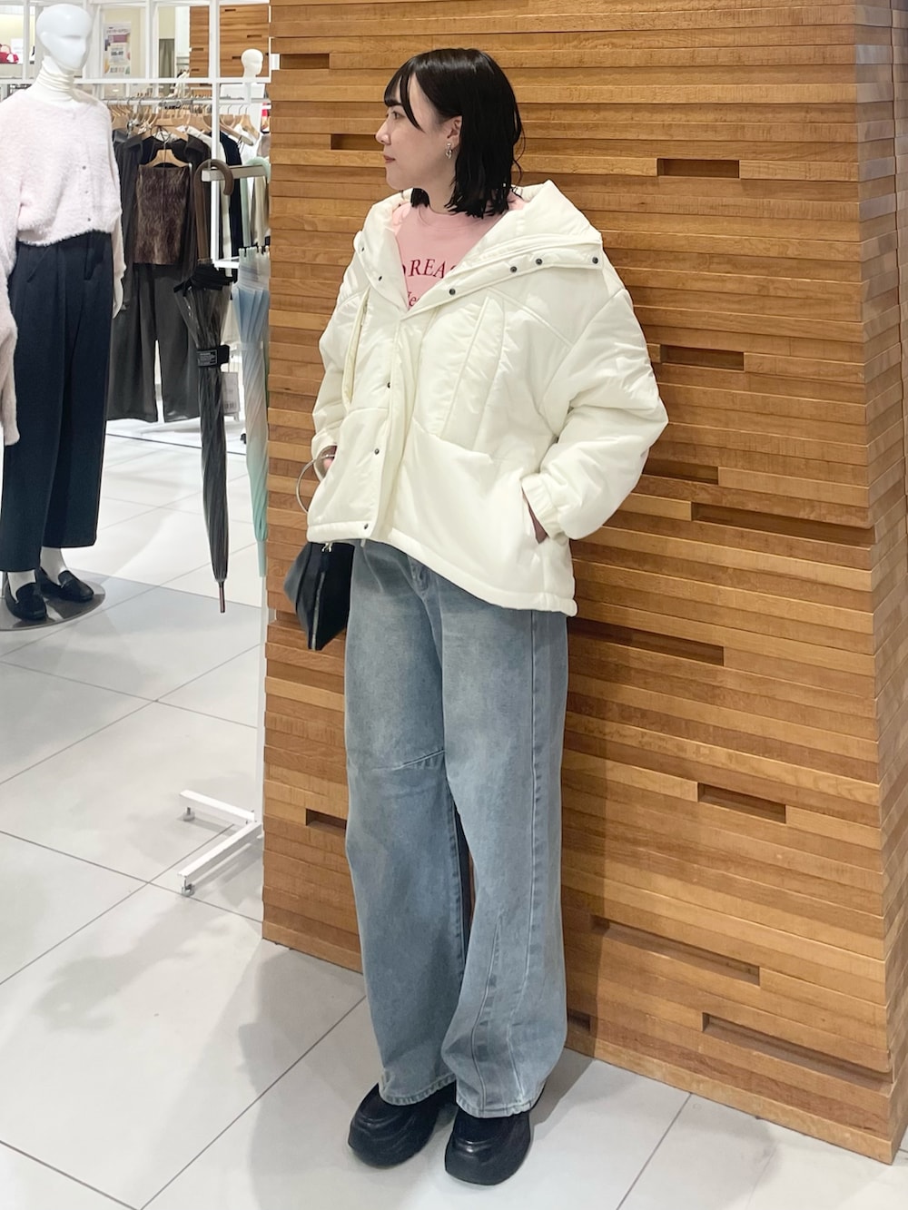 ブラック系のローファー、シルバー系のハンドバッグ、ピンク系のスウェットを着用したレディースの秋コーディネートの2枚目の写真