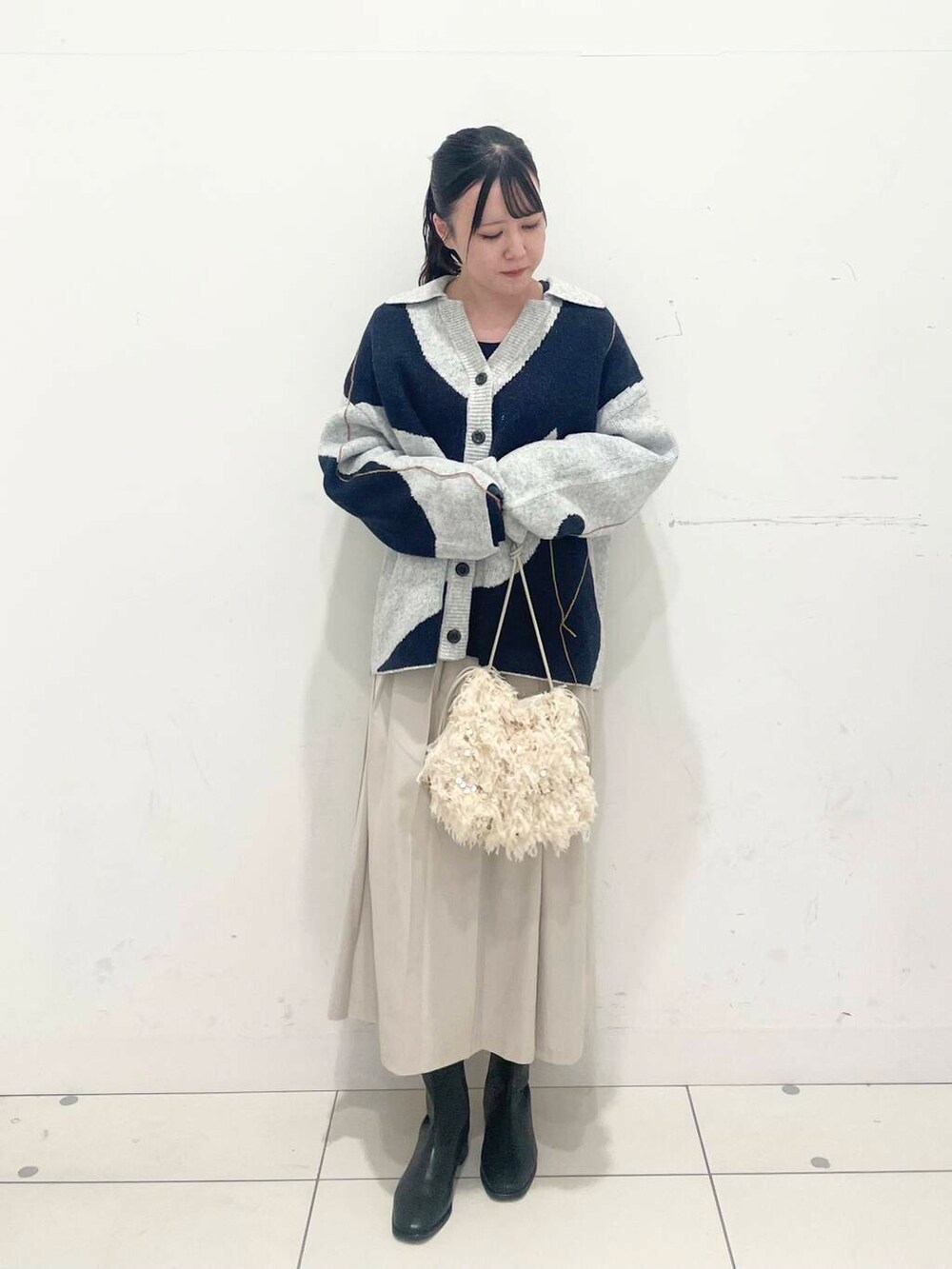 ホワイト系のハンドバッグ、ブラック系のブーツ、ブルー系のTシャツ/カットソーを着用したレディースの秋コーディネートの2枚目の写真