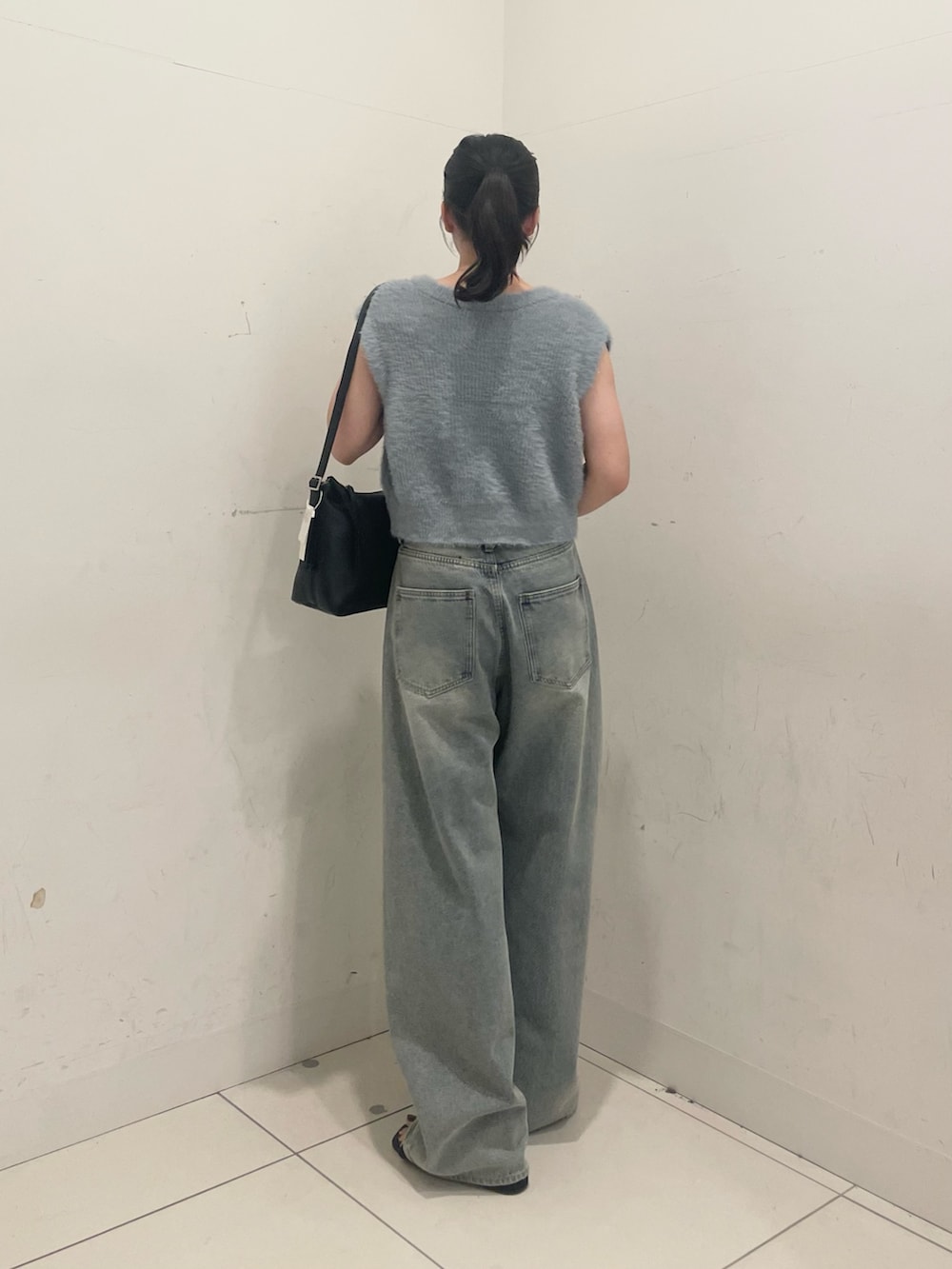 ブルー系のニット/セーター、ブラック系のショルダーバッグ、ブルー系のデニムパンツを着用したレディースの秋コーディネートの3枚目の写真