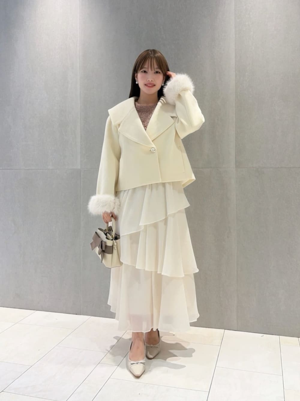 ベージュ系のパンプス、ホワイト系のショルダーバッグ、ピンク系のニット/セーターを着用したレディースの秋コーディネートの2枚目の写真