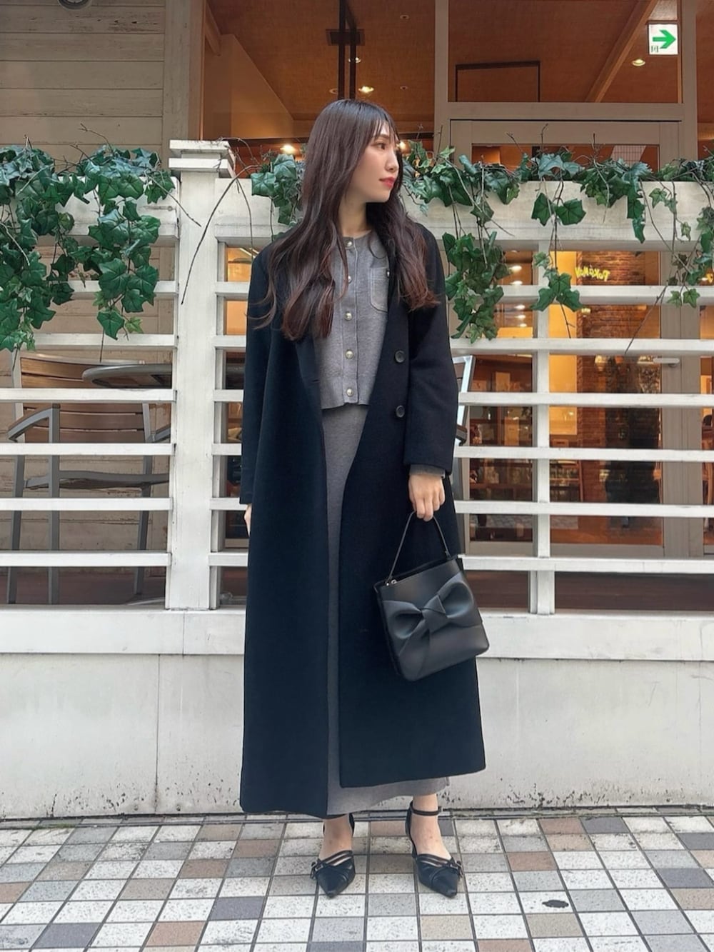 ブラック系のパンプス、ブラック系のショルダーバッグ、グレー系のワンピースを着用したレディースの秋コーディネートの2枚目の写真