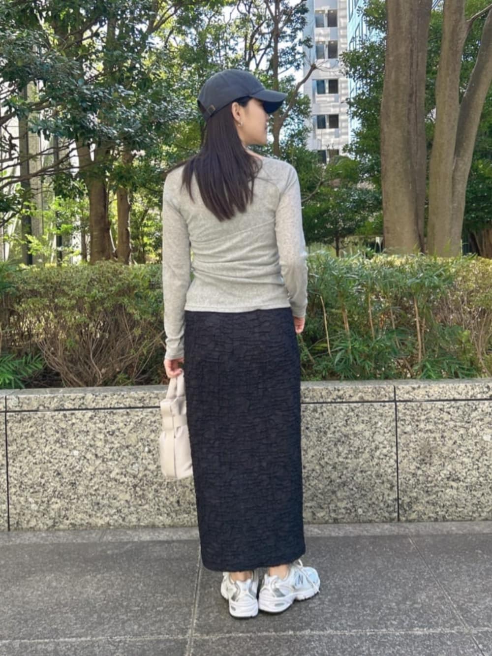 グレー系のTシャツ/カットソー、ブラック系のスカートを着用したレディースの春コーディネートの3枚目の写真