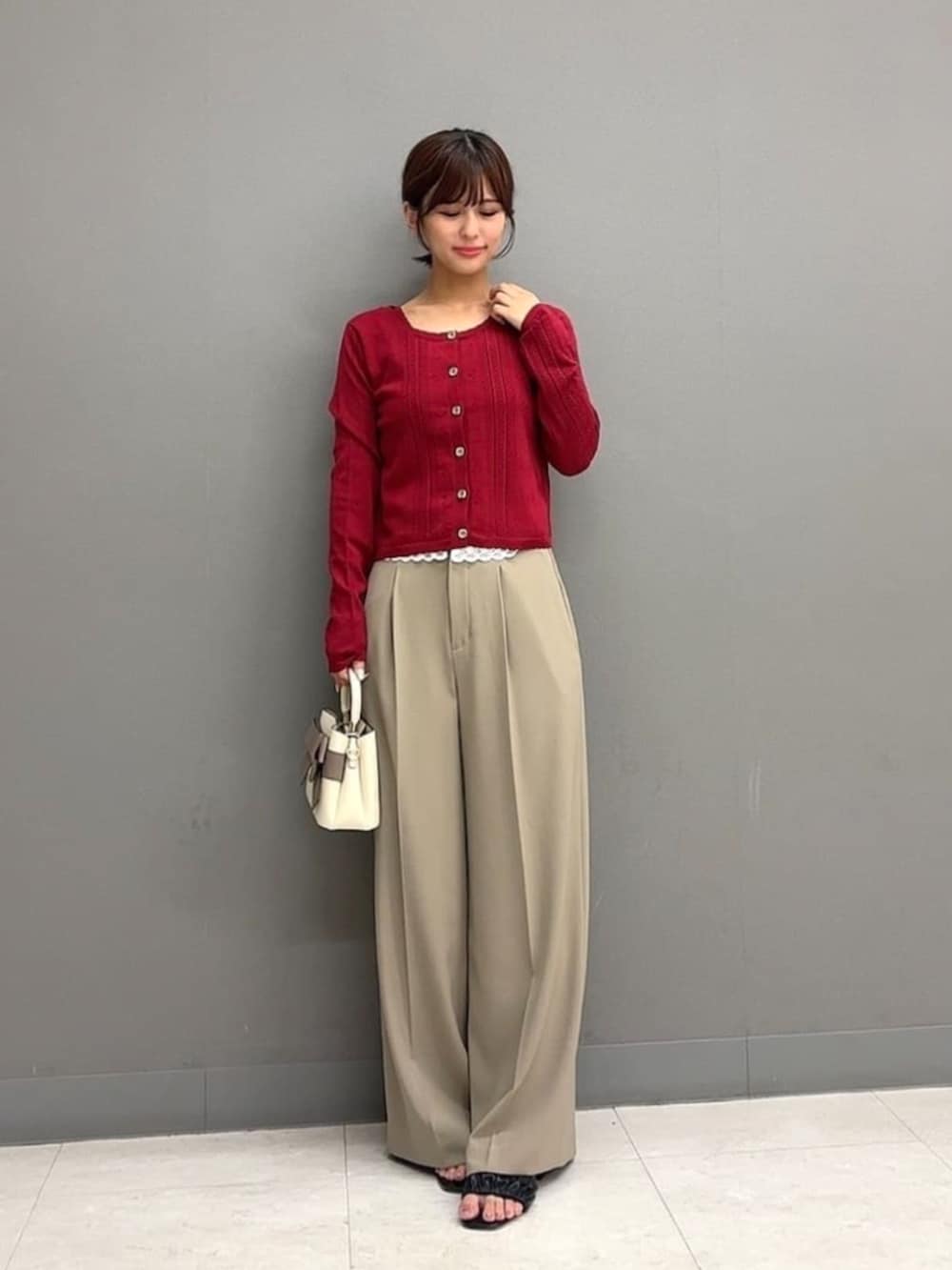 ホワイト系のショルダーバッグ、ベージュ系のその他パンツ、レッド系のアンサンブルを着用したレディースの秋コーディネートの2枚目の写真