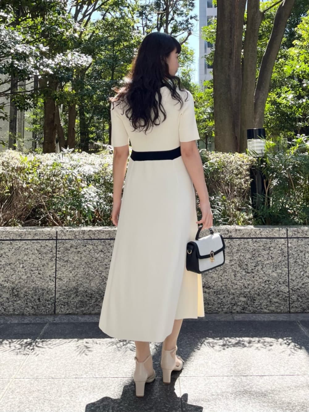 ホワイト系のワンピース、ベージュ系のパンプスを着用したレディースの春コーディネートの3枚目の写真