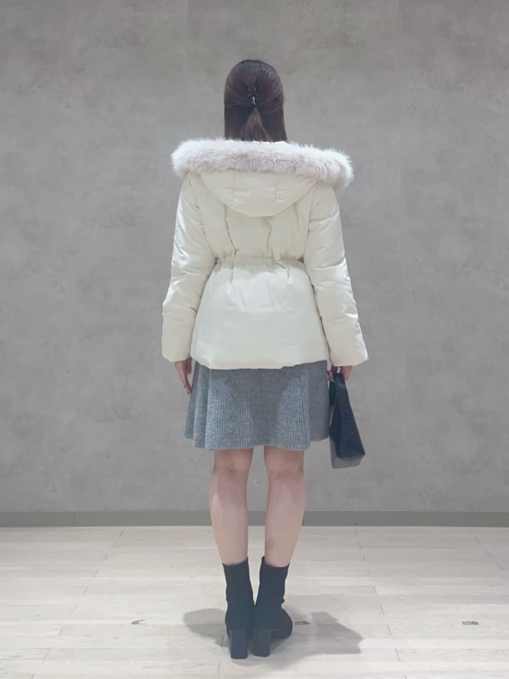 ホワイト系のダウンジャケット/コート、グレー系のワンピースを着用したレディースの冬コーディネートの3枚目の写真