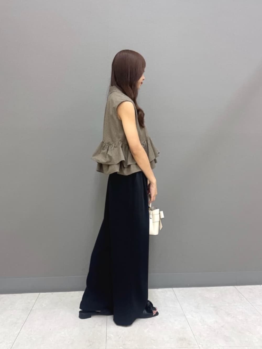 ブラック系のその他パンツ、ホワイト系のショルダーバッグ、ブラウン系のシャツ/ブラウスを着用したレディースの夏コーディネートの2枚目の写真