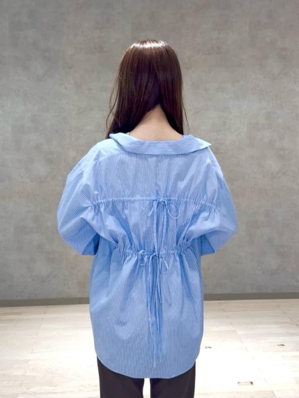 ブラウン系のパンプス、ブラウン系のその他パンツ、ブルー系のシャツ/ブラウスを着用したレディースの秋コーディネートの3枚目の写真