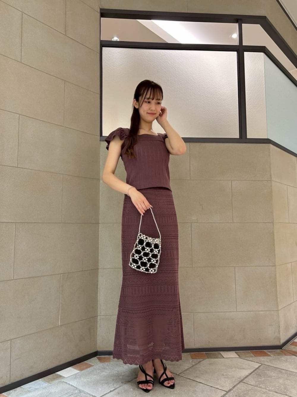 ブラック系のパンプス、レッド系のワンピースを着用したレディースの夏コーディネートの2枚目の写真