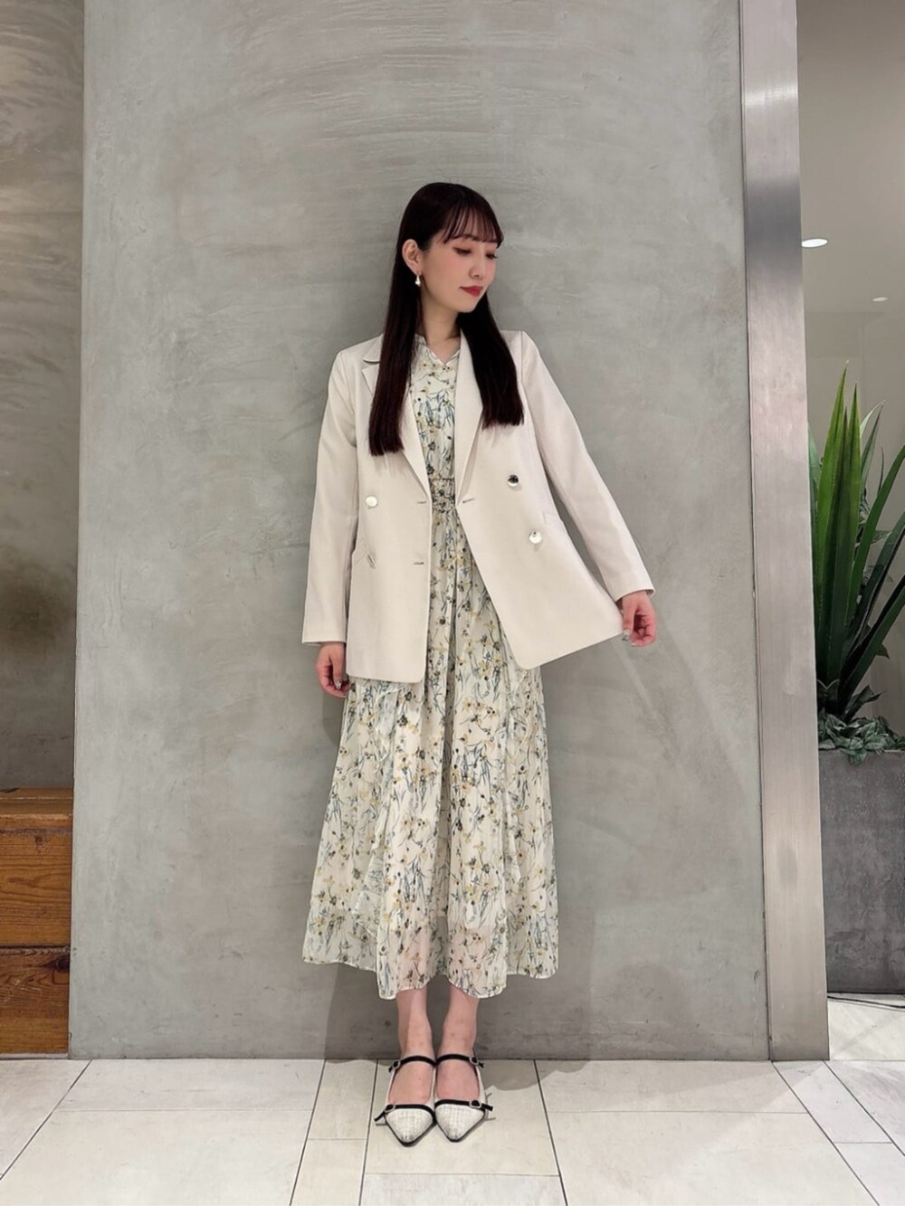 イエロー系のワンピース、ホワイト系のテーラードジャケットを着用したレディースの春コーディネートの3枚目の写真