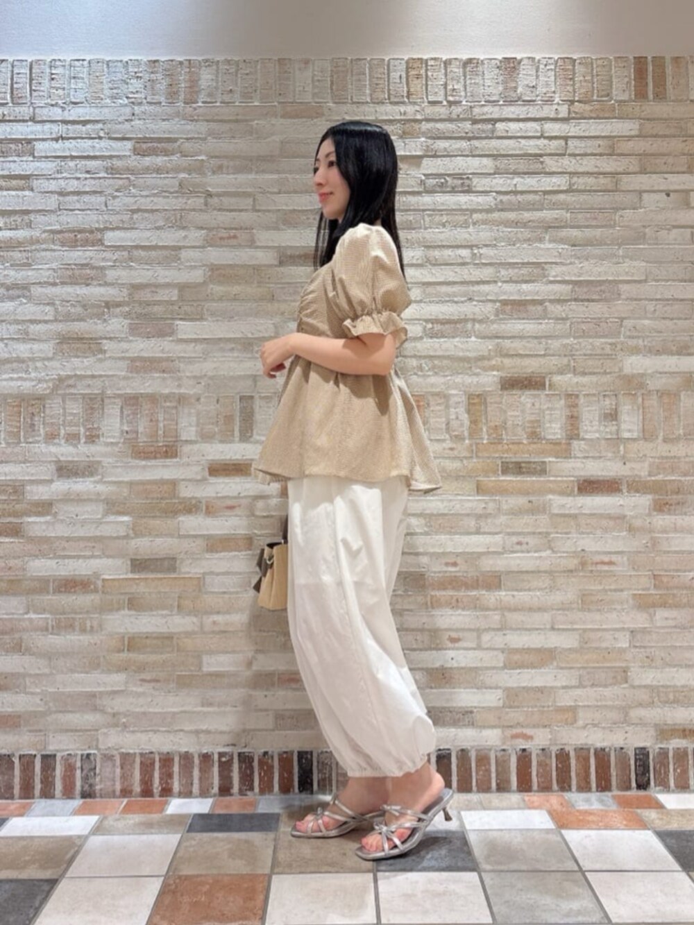 シルバー系のパンプス、ブラウン系のショルダーバッグ、ブラウン系のシャツ/ブラウスを着用したレディースの夏コーディネートの2枚目の写真