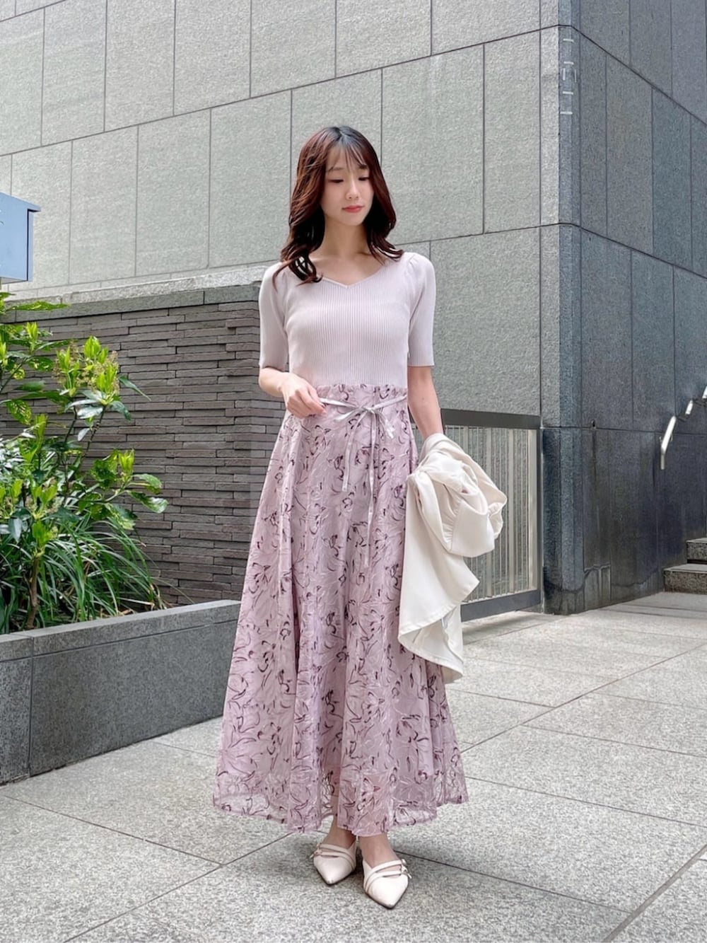 グレー系のワンピース、ホワイト系のブルゾンを着用したレディースの春コーディネートの3枚目の写真