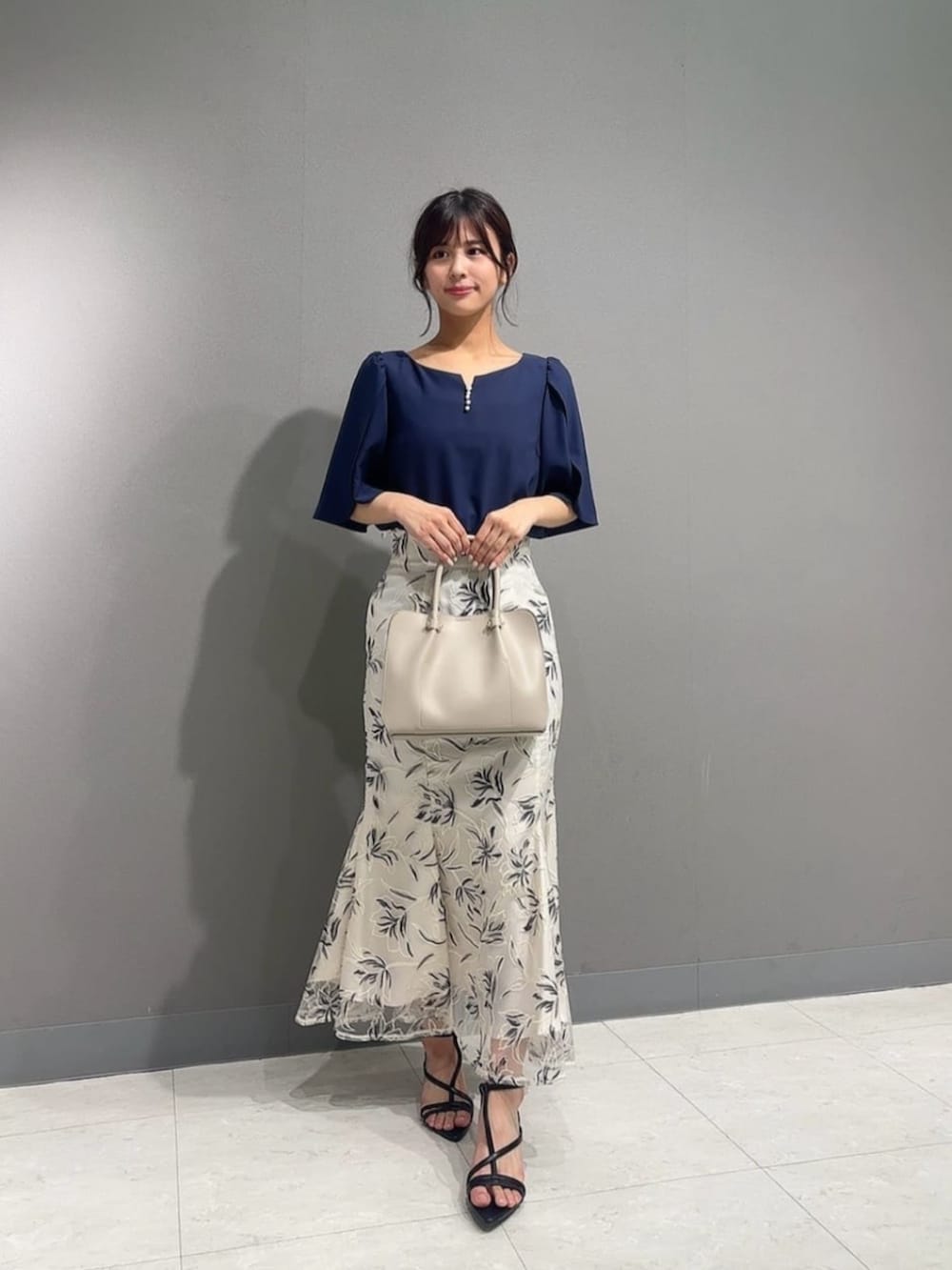 ホワイト系のスカート、ブラック系のパンプス、ブルー系のシャツ/ブラウスを着用したレディースの夏コーディネートの3枚目の写真