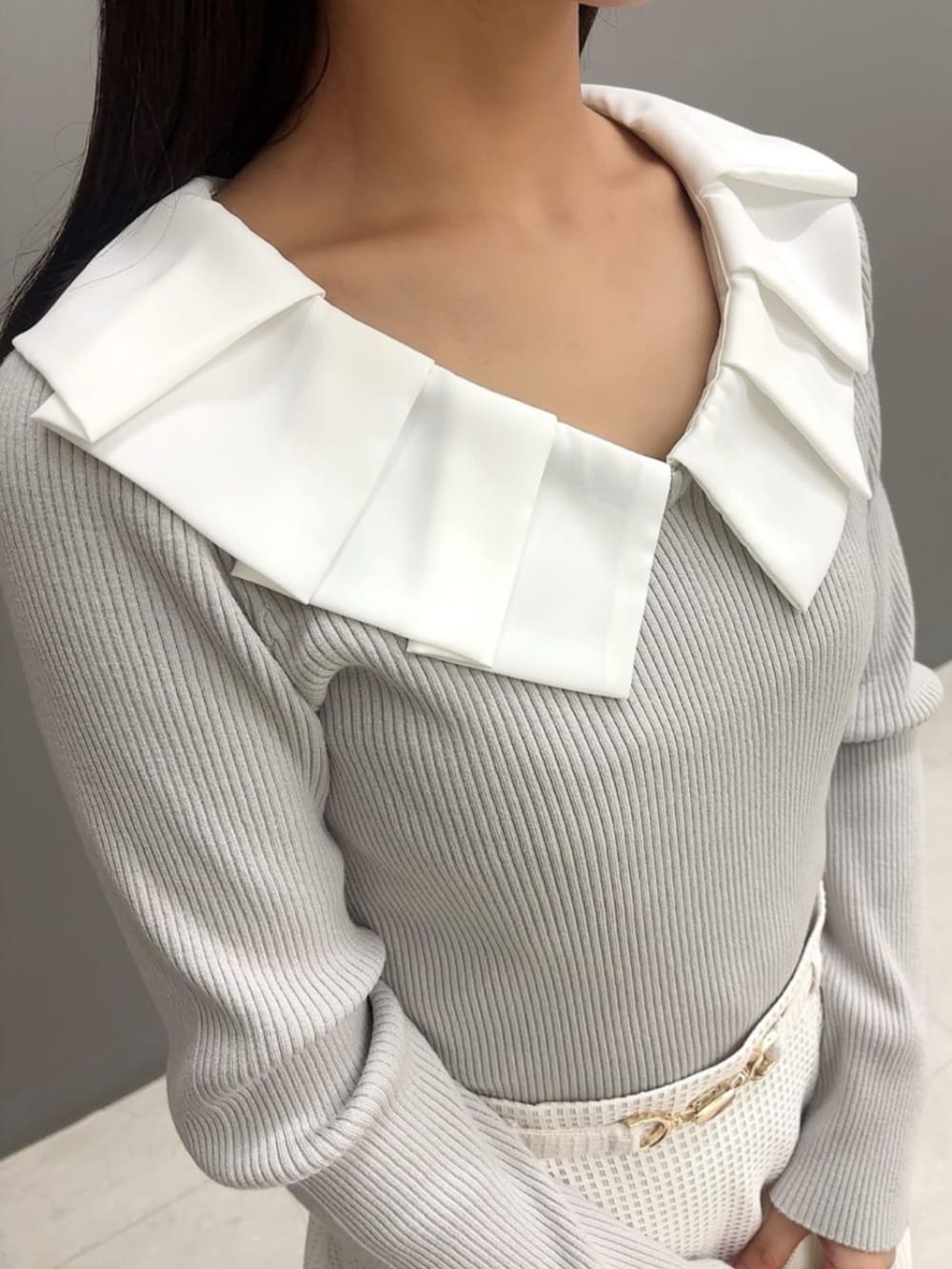 ホワイト系のトートバッグ、グレー系のニット/セーター、ホワイト系のスカートを着用したレディースの冬コーディネートの3枚目の写真