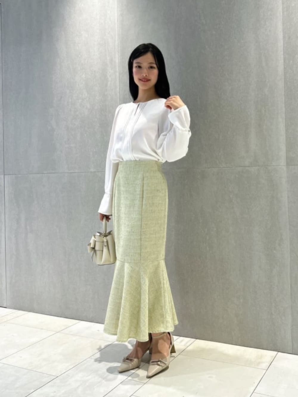 ホワイト系のショルダーバッグ、ベージュ系のパンプス、ホワイト系のシャツ/ブラウスを着用したレディースの冬コーディネートの3枚目の写真