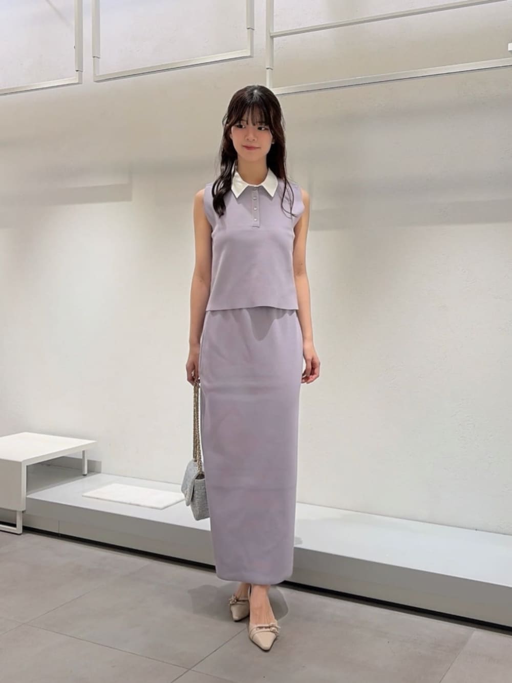 ベージュ系のパンプス、ブルー系のショルダーバッグ、グレー系のワンピースを着用したレディースの夏コーディネートの2枚目の写真