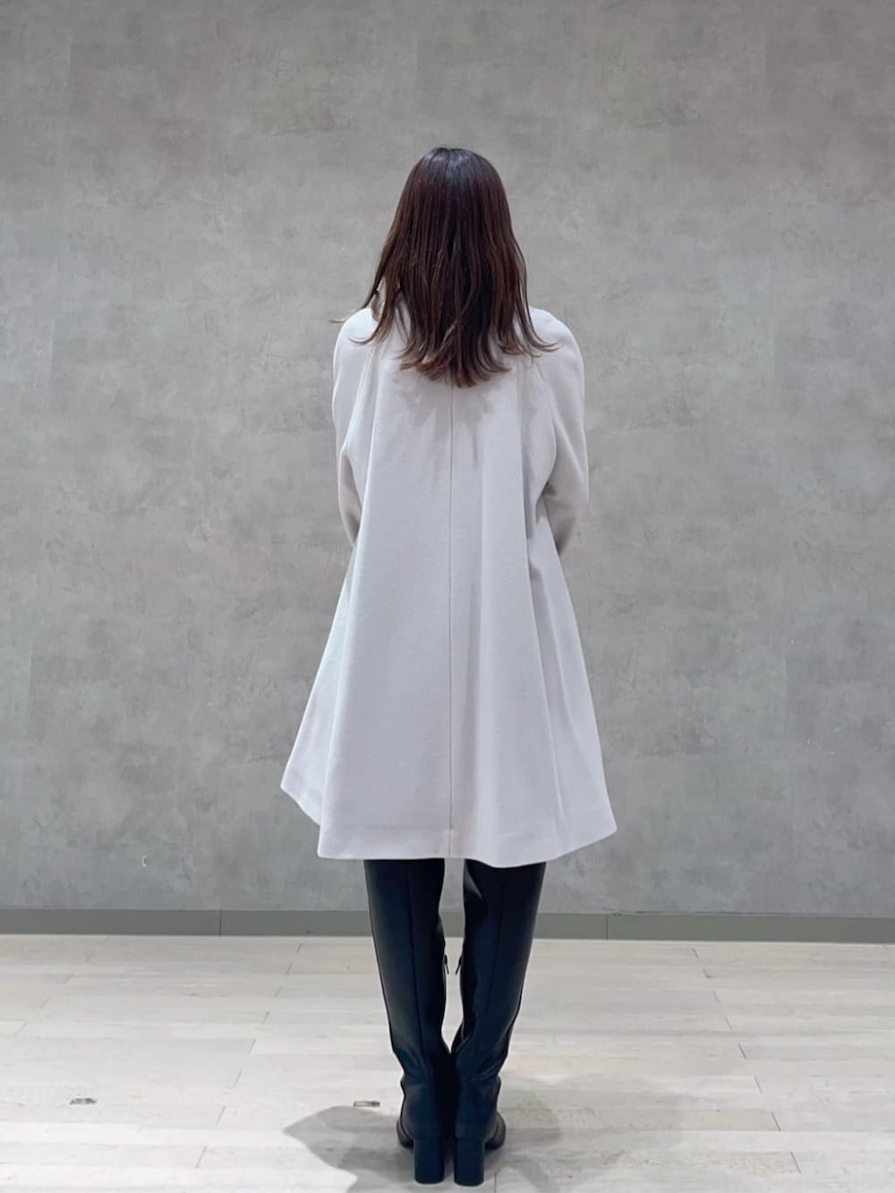 ホワイト系のショルダーバッグ、ブラック系のブーツ、グレー系のノーカラーコートを着用したレディースの秋コーディネートの3枚目の写真