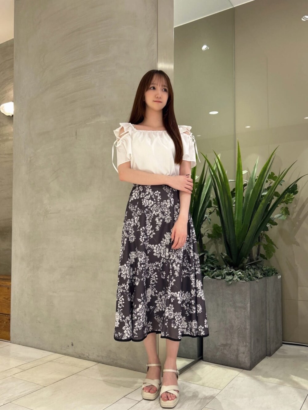 ホワイト系のシャツ/ブラウス、グレー系のスカートを着用したレディースの夏コーディネートの2枚目の写真