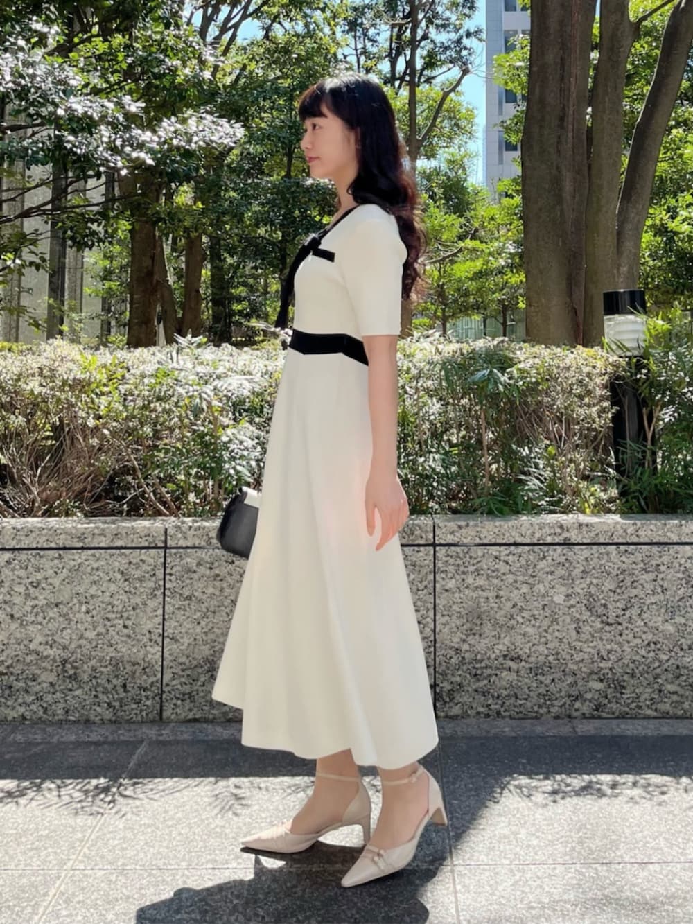 ホワイト系のワンピース、ベージュ系のパンプスを着用したレディースの春コーディネートの2枚目の写真