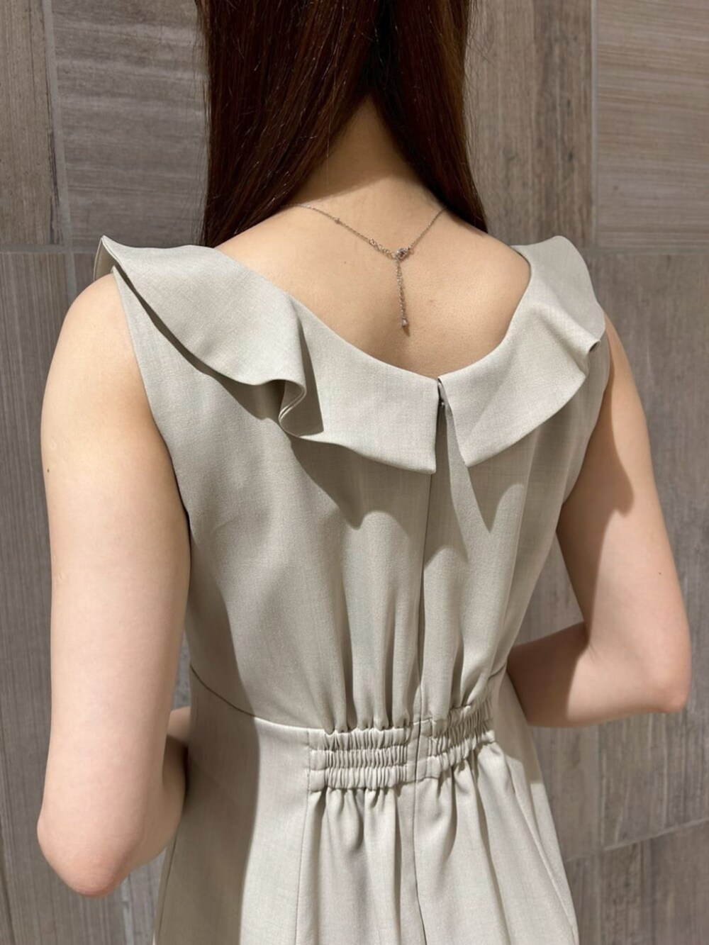 ホワイト系のパンプス、ベージュ系のワンピース、ブラウン系のショルダーバッグを着用したレディースの夏コーディネートの3枚目の写真