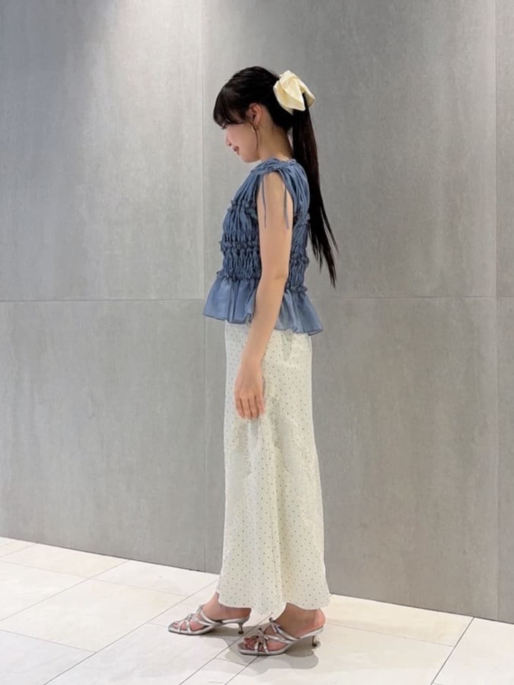 シルバー系のパンプス、ホワイト系のスカート、ブルー系のシャツ/ブラウスを着用したレディースの夏コーディネートの2枚目の写真