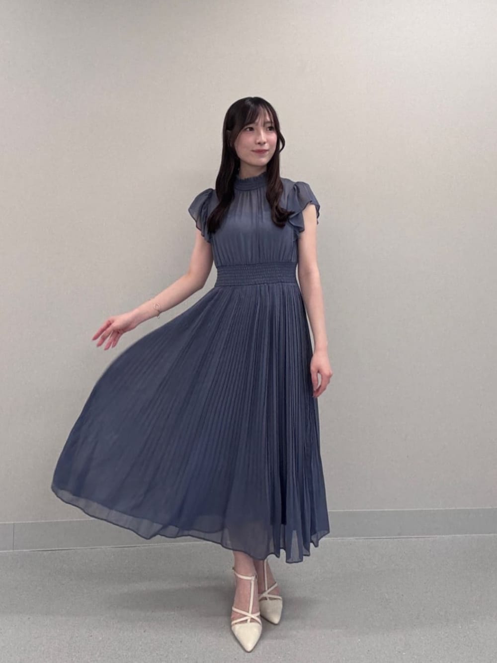 ホワイト系のパンプス、ブルー系のワンピースを着用したレディースの秋コーディネートの2枚目の写真