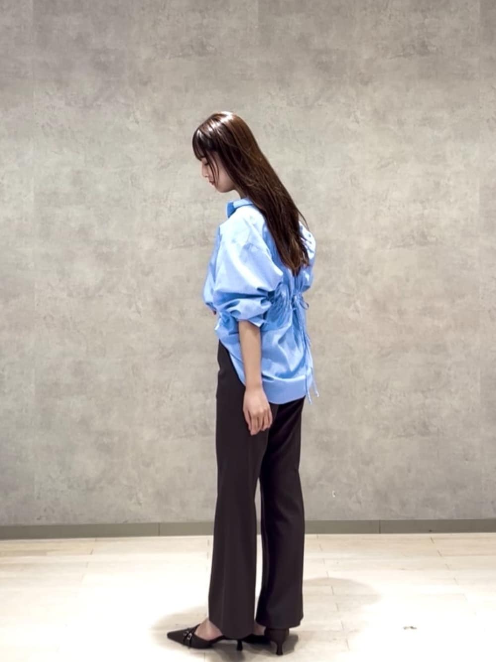 ブラウン系のパンプス、ブラウン系のその他パンツ、ブルー系のシャツ/ブラウスを着用したレディースの秋コーディネートの2枚目の写真