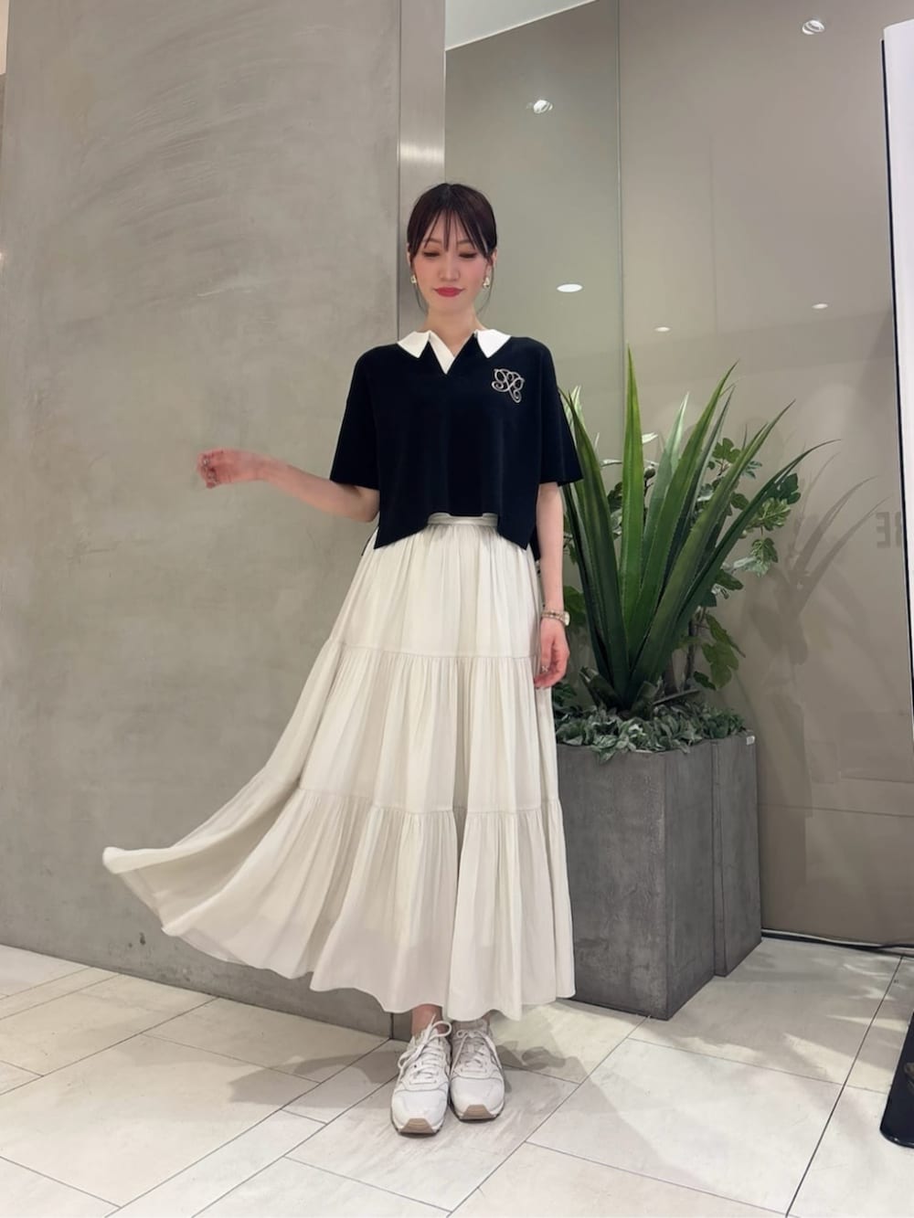 ブラック系のニット/セーター、ホワイト系のスカートを着用したレディースの夏コーディネートの2枚目の写真