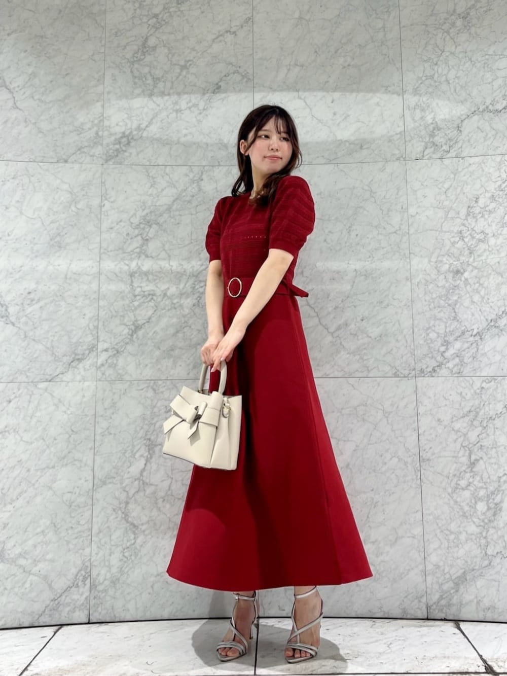 シルバー系のパンプス、レッド系のワンピース、ホワイト系のショルダーバッグを着用したレディースの春コーディネートの2枚目の写真