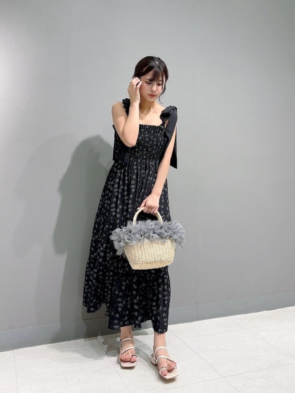 ホワイト系のパンプス、ブルー系のカーディガン/ボレロ、ブラック系のワンピースを着用したレディースの春コーディネートの3枚目の写真