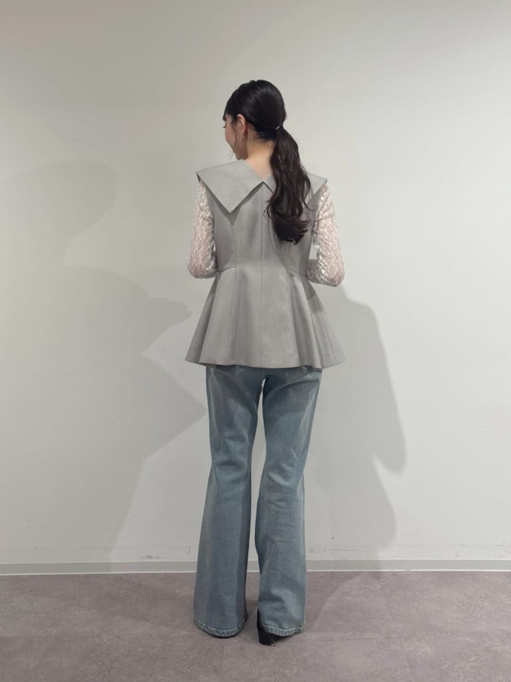 ホワイト系のTシャツ/カットソー、グレー系のベスト、ブルー系のデニムパンツを着用したレディースの春コーディネートの3枚目の写真