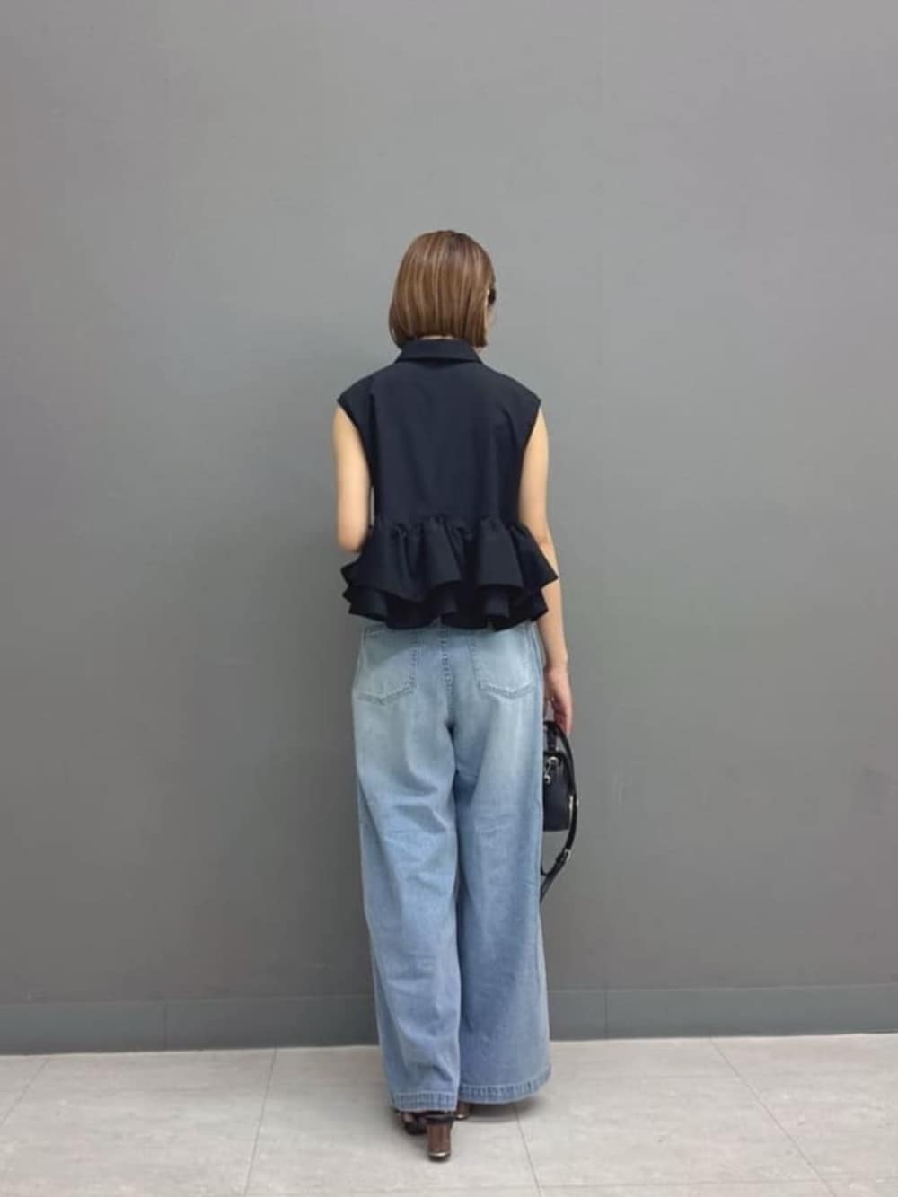 ブラック系のショルダーバッグ、ブルー系のその他パンツ、ブラック系のシャツ/ブラウスを着用したレディースの夏コーディネートの3枚目の写真