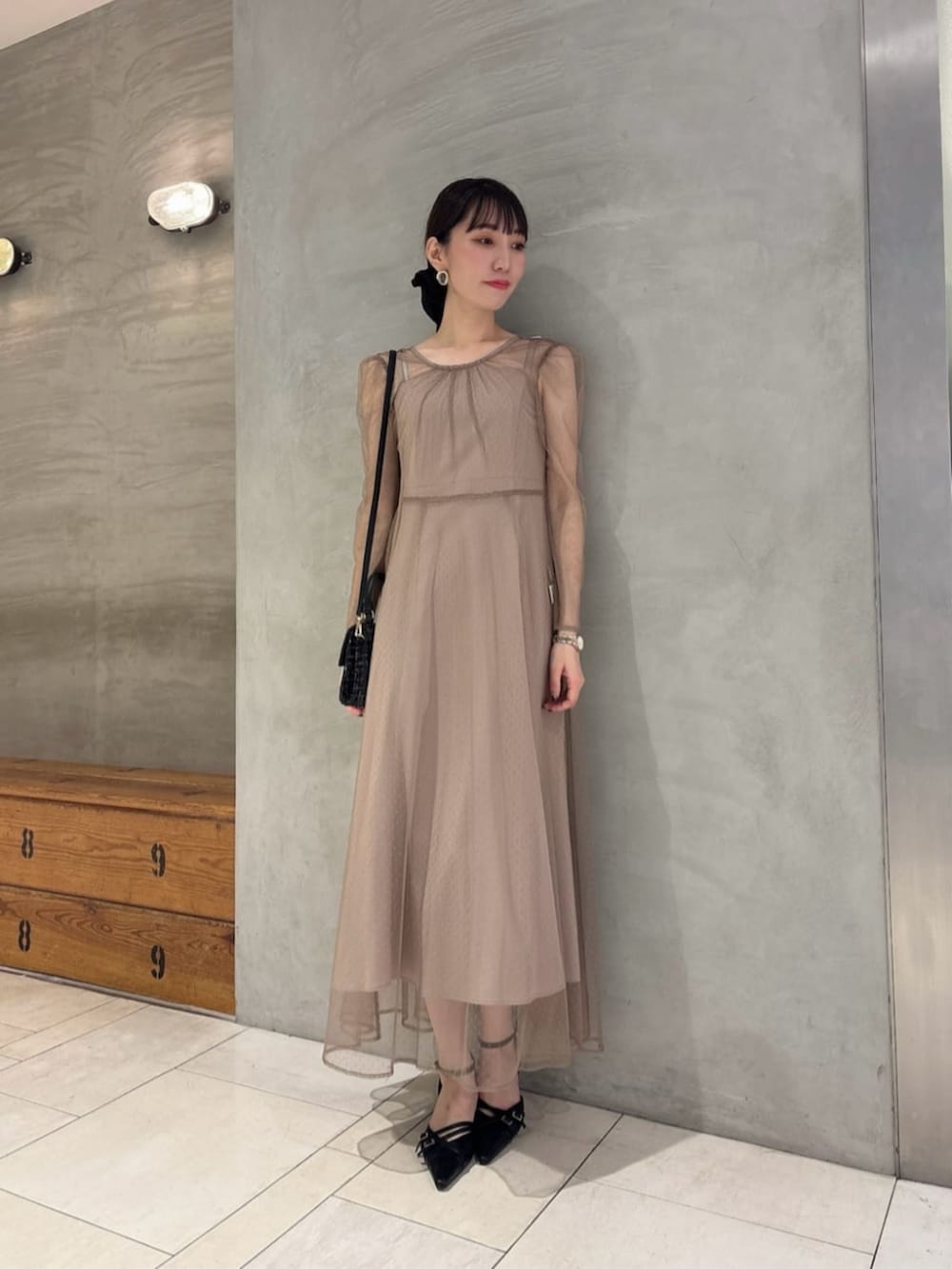 ブラック系のショルダーバッグ、ブラック系のパンプス、ベージュ系のワンピースを着用したレディースの秋コーディネートの2枚目の写真