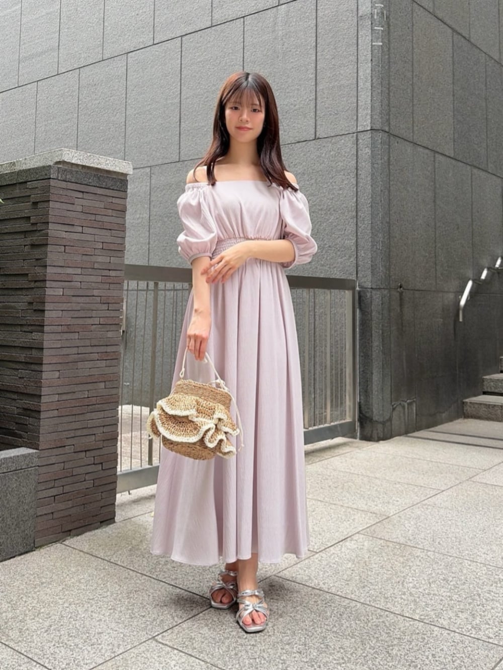 シルバー系のパンプス、ベージュ系のショルダーバッグ、ピンク系のワンピースを着用したレディースの春コーディネートの2枚目の写真
