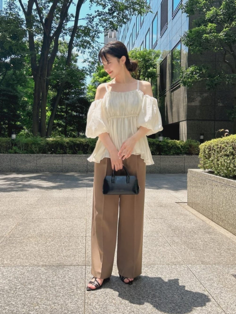 ブラック系のパンプス、ホワイト系のシャツ/ブラウス、ブラウン系のその他パンツを着用したレディースの夏コーディネートの2枚目の写真