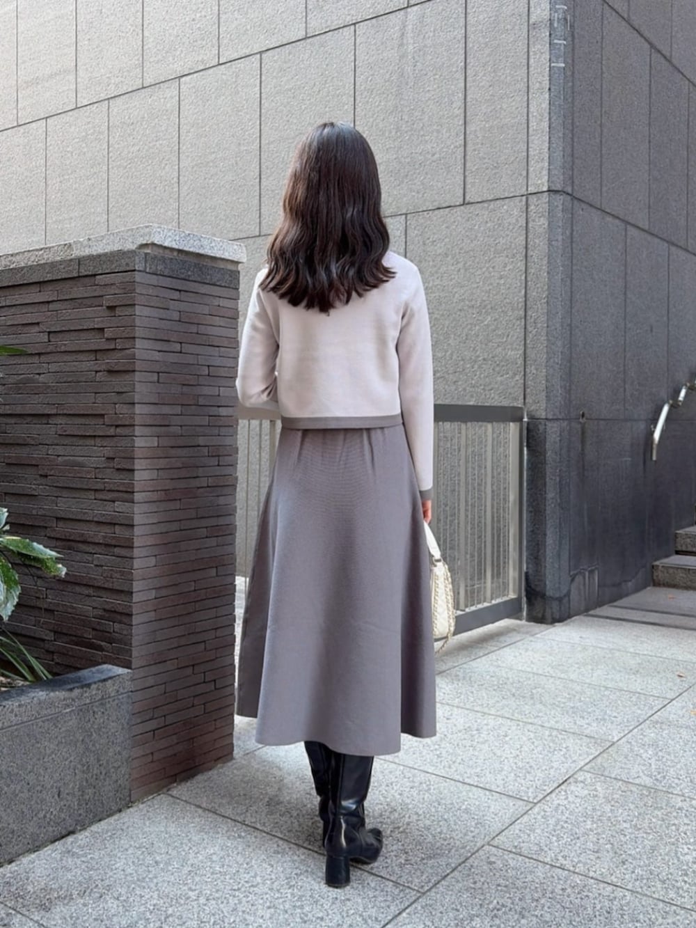 ホワイト系のショルダーバッグ、グレー系のワンピースを着用したレディースの冬コーディネートの2枚目の写真