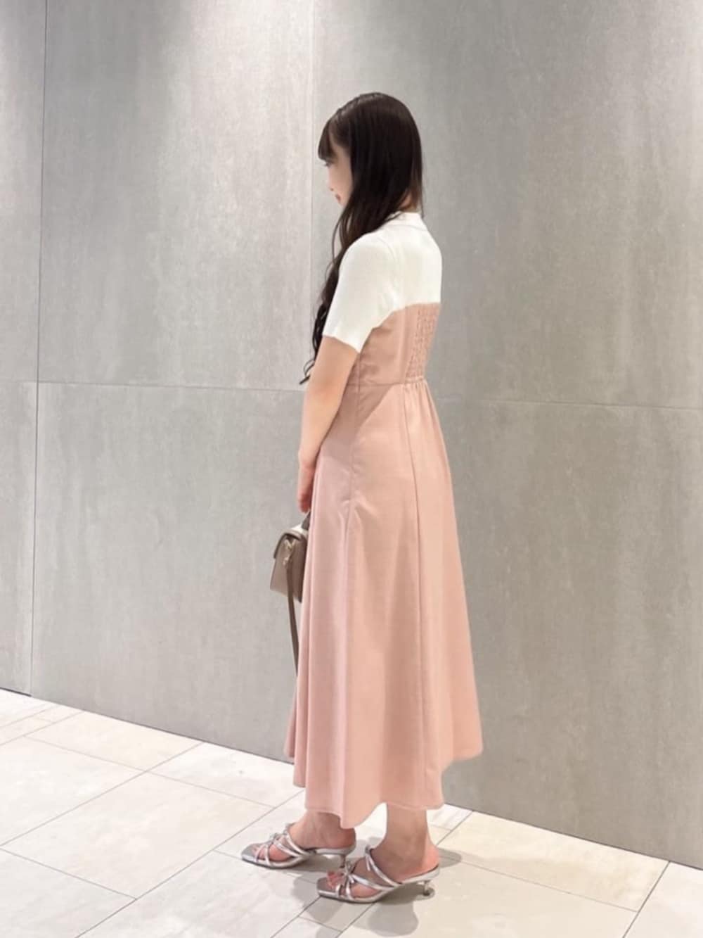 グレー系のショルダーバッグ、シルバー系のパンプス、ピンク系のワンピースを着用したレディースの夏コーディネートの2枚目の写真