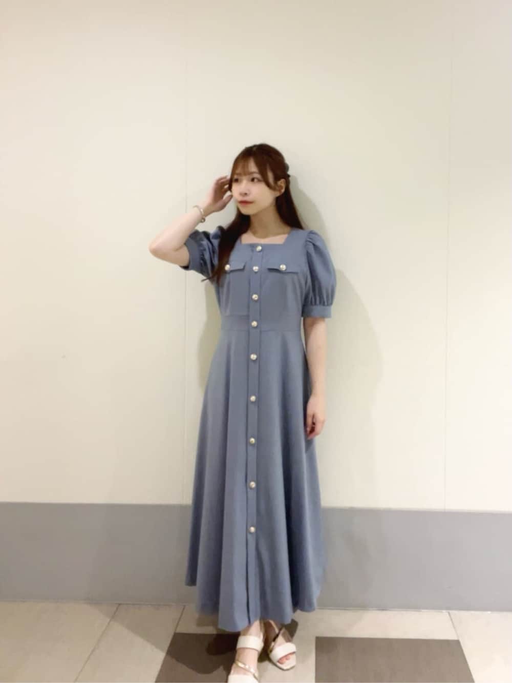 ブルー系のワンピース、ホワイト系のショルダーバッグを着用したレディースの夏コーディネートの2枚目の写真