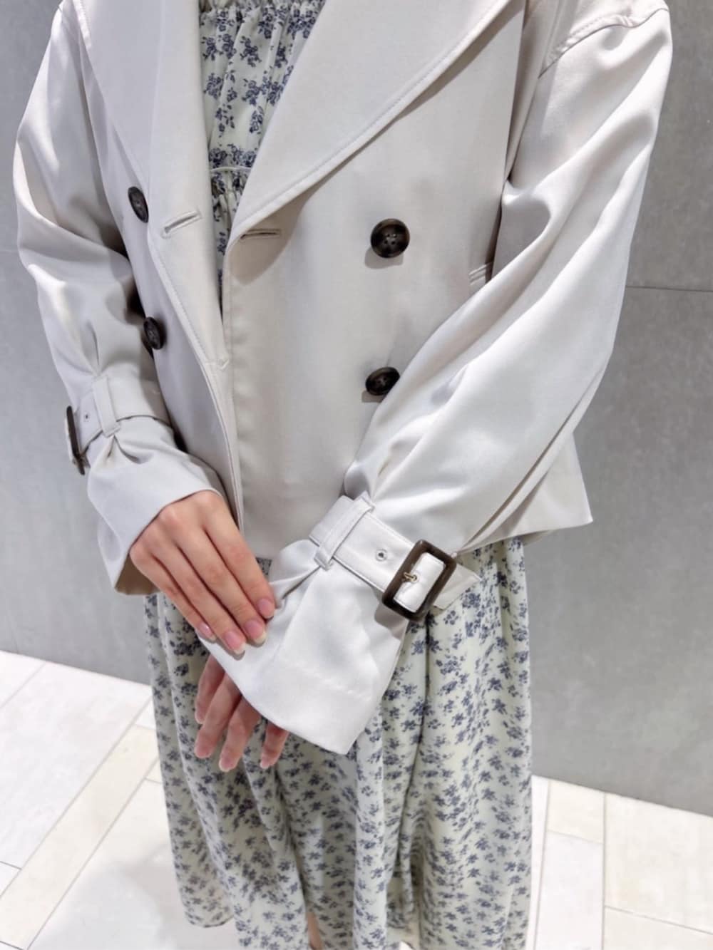 ホワイト系のトレンチコート、ホワイト系のワンピースを着用したレディースの春コーディネートの3枚目の写真